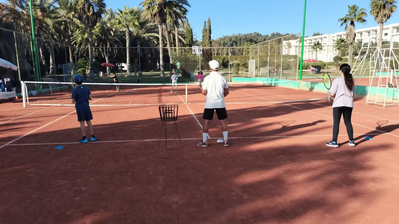 Cours collectif du matin sur un court en terre battue du club Tennis Agadir Training