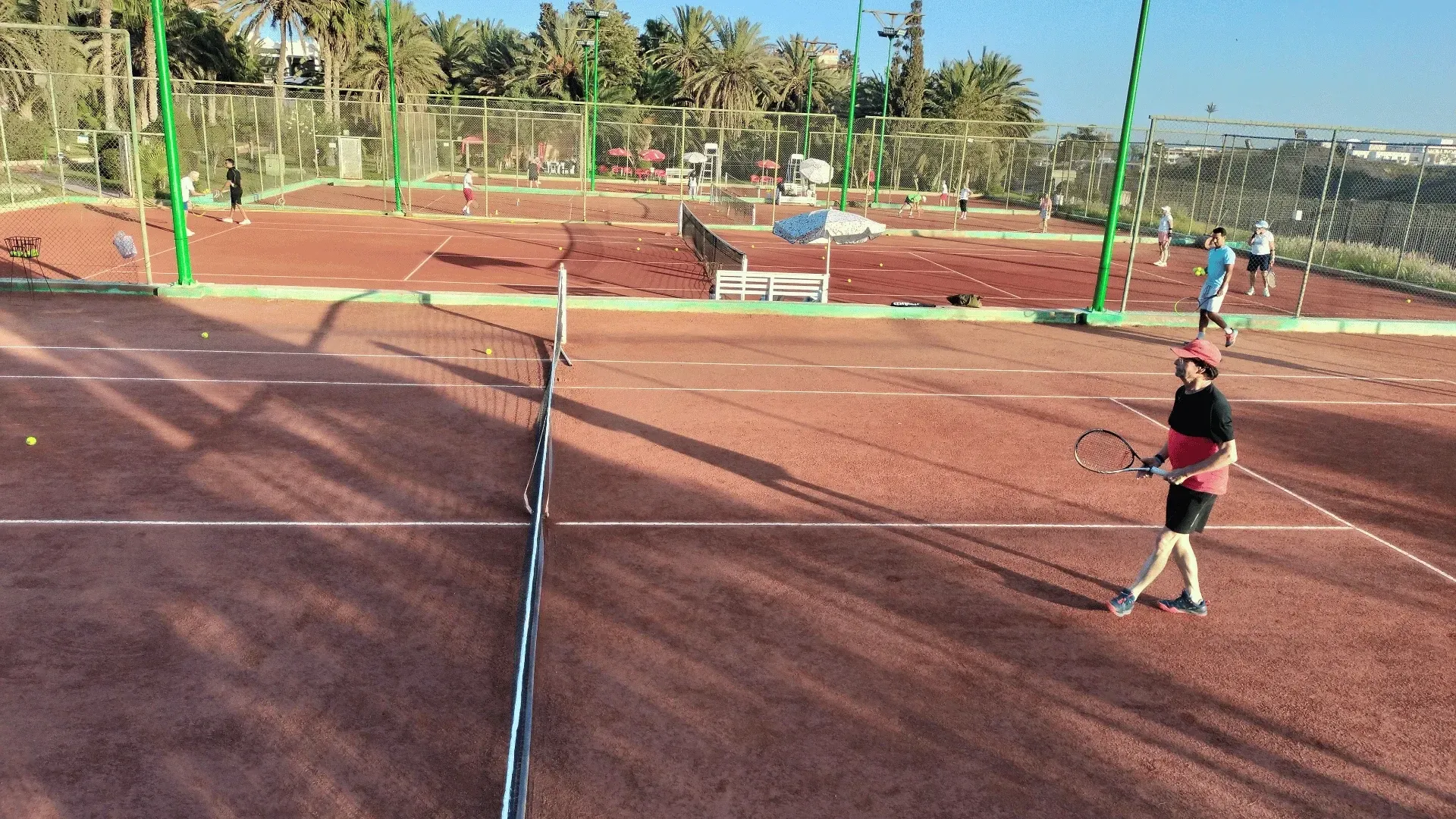 Campi da tennis a noleggio ad Agadir: vista d'insieme dei campi in terra rossa del circolo, palme sullo sfondo